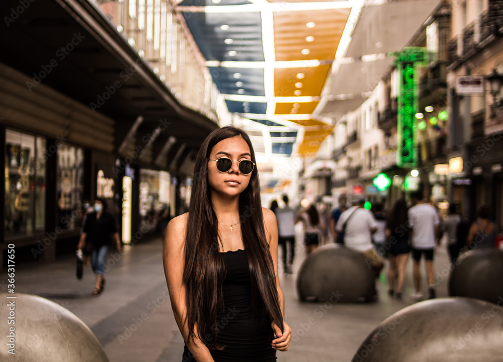 Young hispanic woman posing on a summer day while strolling through a square Young hispanic woman posing on a summer day while strolling through a square