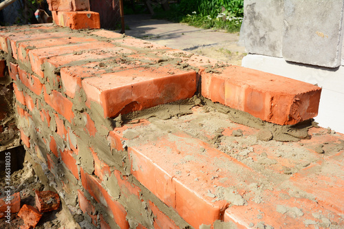 A close-up on bricklaying the foundation, brickwork during new house construction.