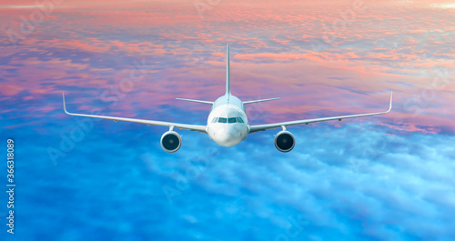 White passenger airplane in the sunset clouds - Travel by air transport