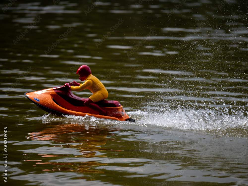 RC controlled jet ski model on lake. Active summer vacation for school child.
