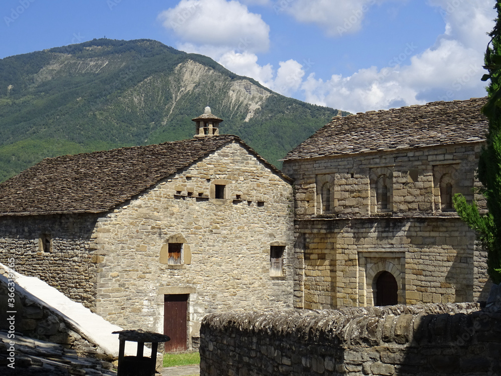 View of a traditional house and the Mozarab Pre-Romanesque or Romanesque Church of San Pedro de Larrede in the Serrablo Region. 10th-11th century. Aragon. Spain. View of a traditional house and the Mozarab Pre-Romanesque or Romanesque Church of San Pedro de Larrede in the Serrablo Region. 10th-11th century. Aragon. Spain.