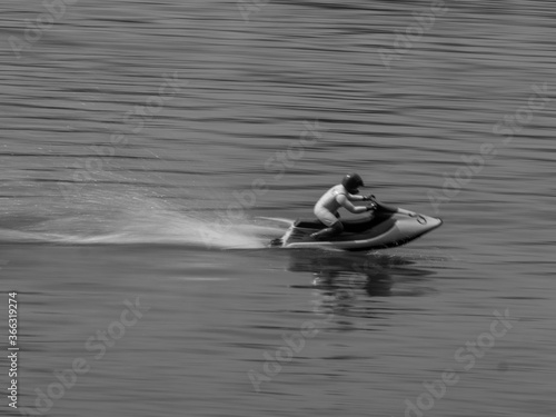 RC controlled jet ski model on lake black and white. © Milos
