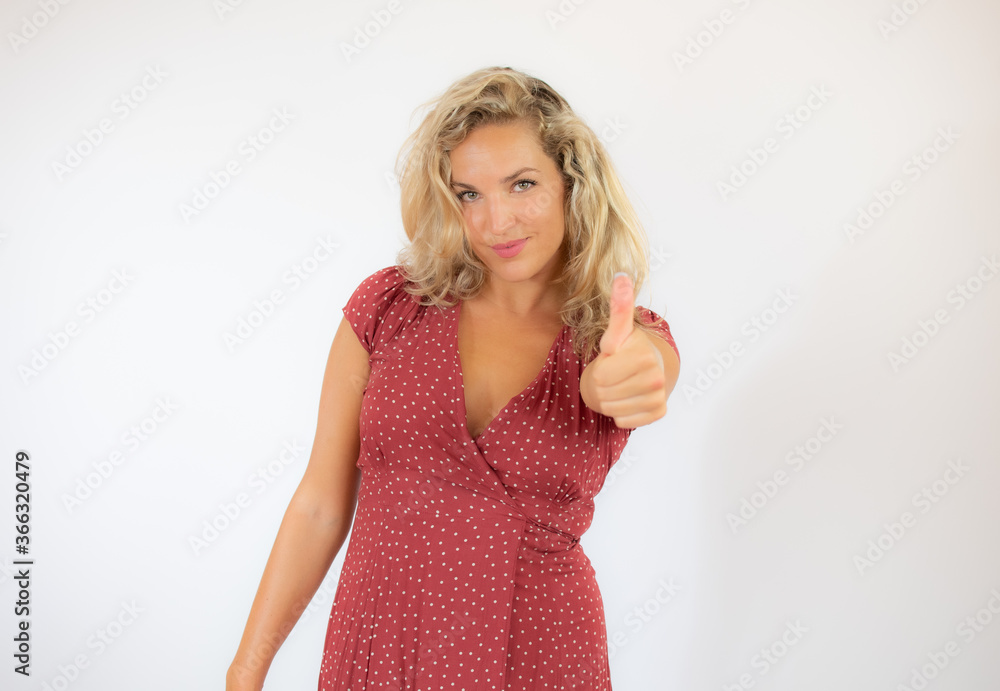Beautiful smiling blonde woman in a red dress with finger up gesture Beautiful smiling blonde woman in a red dress with finger up gesture