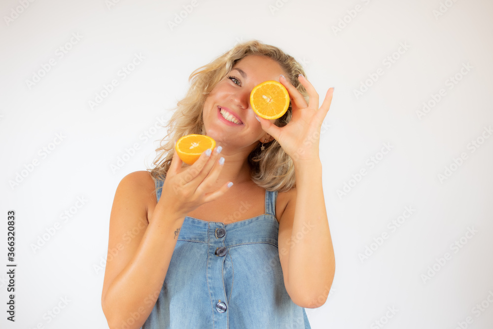 Pretty blonde woman in blue dress smiling with an orange in the eye Pretty blonde woman in blue dress smiling with an orange in the eye