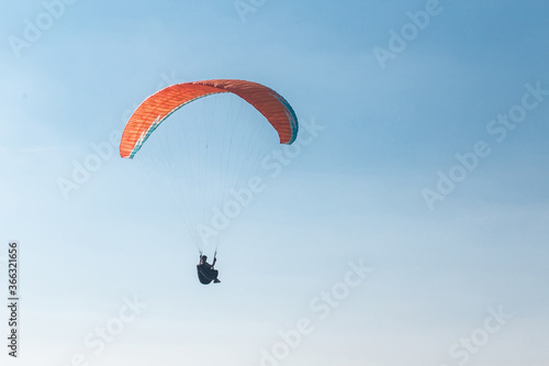 Man paragliding with a blue backround