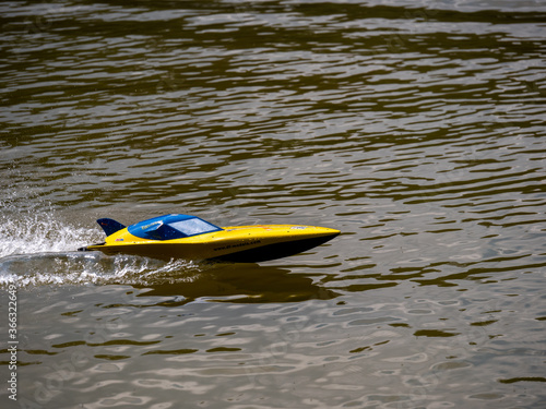RC controlled speedboat model on lake. Active summer vacation for school child.