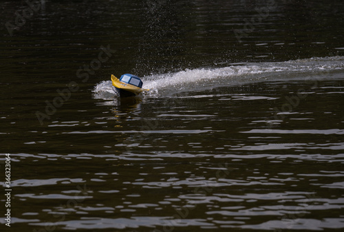 RC controlled speedboat model on lake. Active summer vacation for school child.