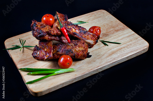Fresh fried meat. Medium roast beef steak on a wooden chopping Board, with tomatoes, peppers and herbs. The view from the top.
