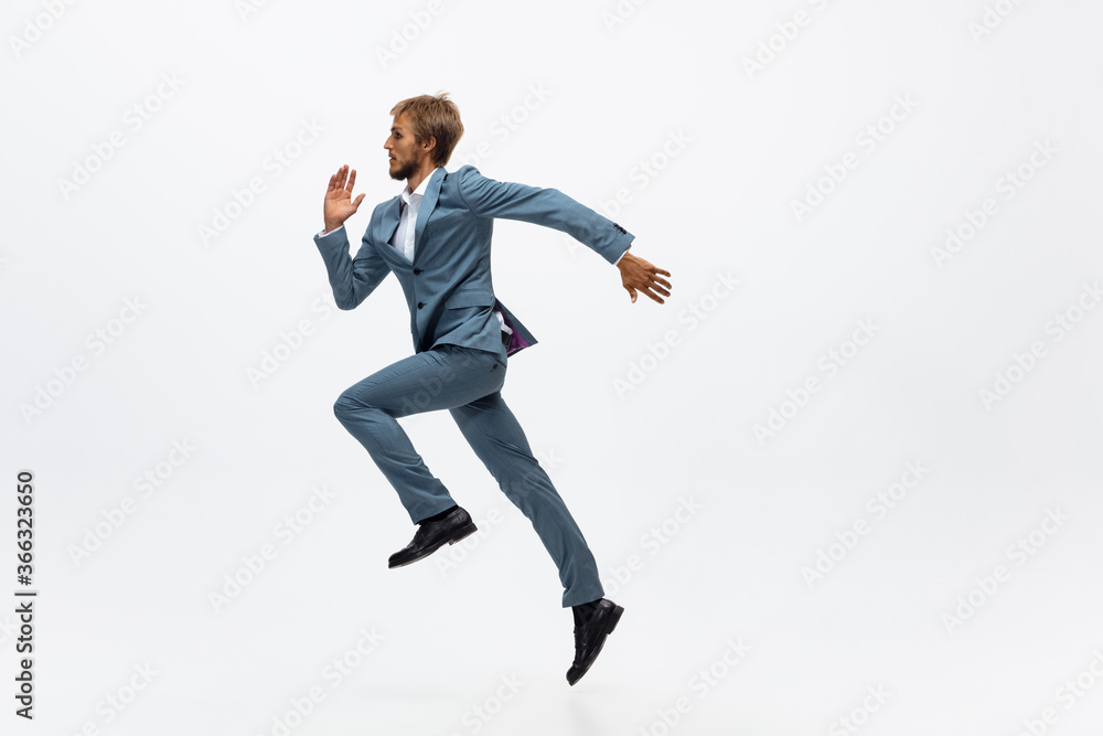 Start up. Man in office clothes running, jogging on white background like professional athlete, sportsman. Unusual look for businessman in motion, action with ball. Sport, healthy lifestyle