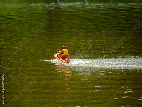 RC controlled jet ski model on lake.