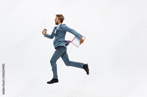 Leader. Man in office clothes running, jogging on white background like professional athlete, sportsman. Unusual look for businessman in motion, action with ball. Sport, healthy lifestyle, creativity.
