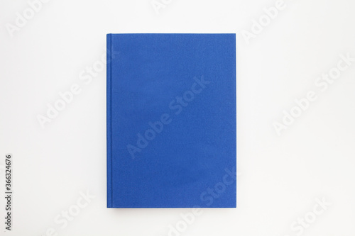 Blue book with no title standing on white background