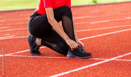 A female athlete close up on a jogging track on the sports track