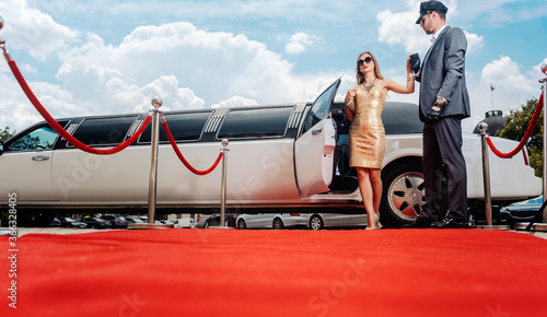 Foto Driver helping VIP woman or star out of limo on red carpet