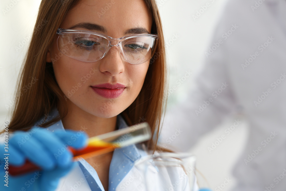 Young laboratory assistant wearing uniform while working with chemical reagents, waiting for reaction Young laboratory assistant wearing uniform while working with chemical reagents, waiting for reaction
