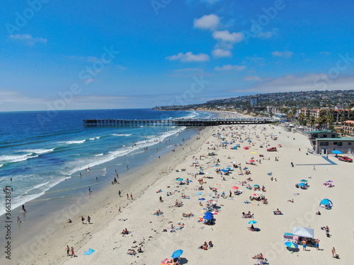 Aerial view of people at the beach near the pier with during blue summer day. Pacific Beach in San Diego, California  © Unwind