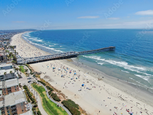 Aerial view of people at the beach near the pier with during blue summer day. Pacific Beach in San Diego, California  © Unwind