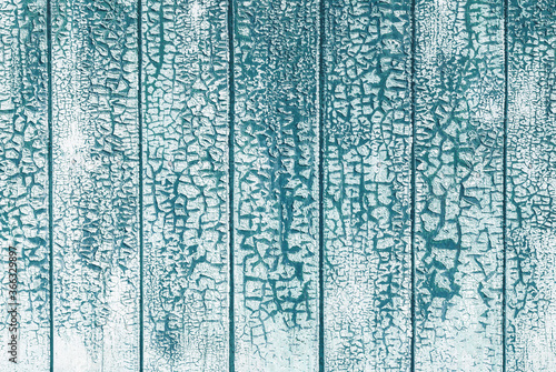 cracked white paint textured background on teal blue wooden planks