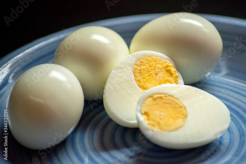 Hard boiled eggs on blue plate and dark background photo