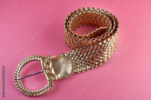 Gold fashionable woman belt on pink background