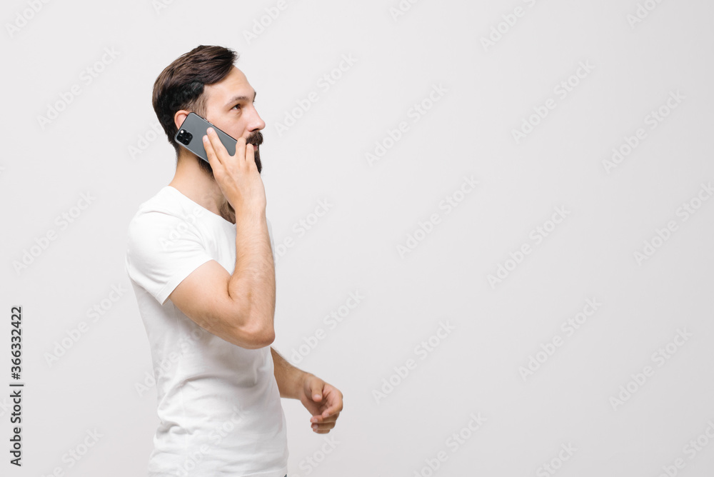 Pensive young man is using a mobile phone. space for text Pensive young man is using a mobile phone. space for text
