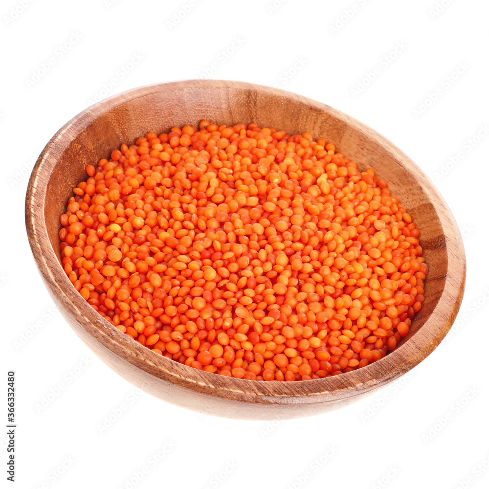 Heap of orange lentils in the wooden bowl isolated on a white background. Top view. Heap of orange lentils in the wooden bowl isolated on a white background. Top view.