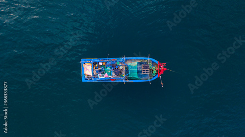 Colourful Vietnamese wooden fishing boat in the sea in Muine. Drone photo.
