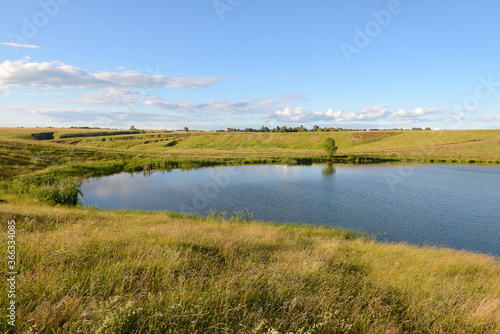 A small reservoir in a ravine on a summer evening