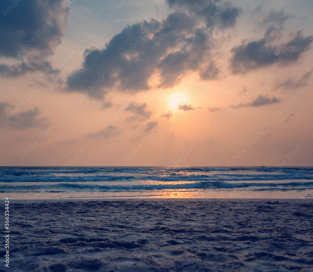 Fototapeta premium Dawn on the ocean. Sea with waves, sandy beach. Image with retro tone. Beautiful landscape
