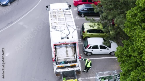 Aerial shot of garbage men with trash truck picking up the city garbage. Waste disposal