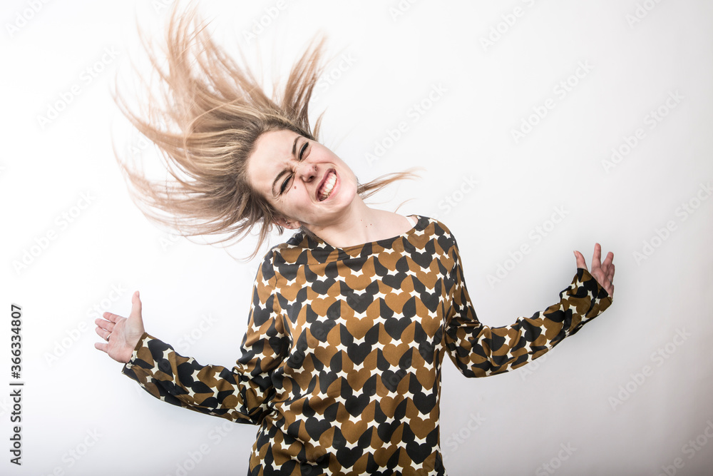 ragazza bionda vestita casual balla divertita e tira capelli cielo , isolata su sfondo bianco ragazza bionda vestita casual balla divertita e tira capelli cielo , isolata su sfondo bianco
