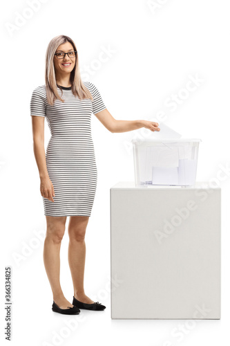 Full length portrait of a young woman voting at election photo