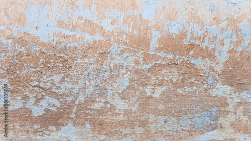 Old shabby wall with peeling plaster. Cracked stucco texture.