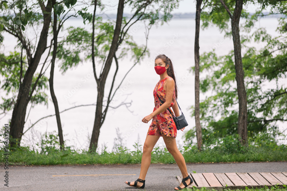 COVID-19 Mandatory mask wear in city Woman walking wearing mask protection as prevention for coronavirus outside in city park summer lifestyle outdoor. Corona virus. COVID-19 Mandatory mask wear in city Woman walking wearing mask protection as prevention for coronavirus outside in city park summer lifestyle outdoor. Corona virus.