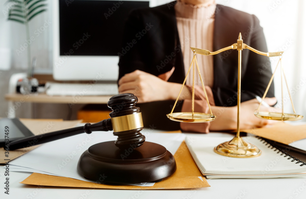 Business and lawyers discussing contract papers with brass scale on desk in office. Law, legal services, advice, justice and law concept picture with film grain effect Business and lawyers discussing contract papers with brass scale on desk in office. Law, legal services, advice, justice and law concept picture with film grain effect