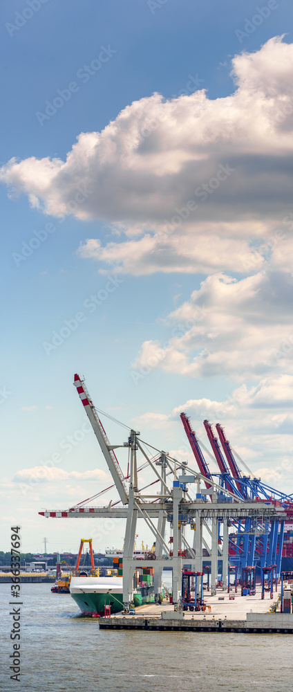 Fototapeta premium Vertorama of a container terminal in the port of hamburg in good weather 