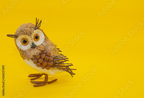 Coruja virando a cabeça olhando fundo amarelo pássaro dourado penas de coruja produto de decoração sala quartos photo