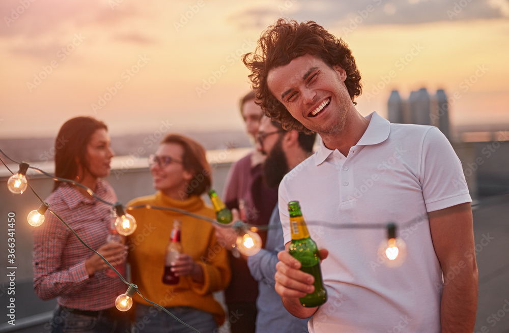 Fototapeta premium Cheerful man with beer during party with friends