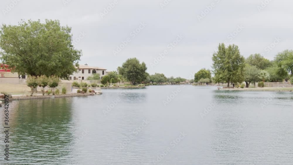 Jib up and over a blue park bench to revel a lake and community with waterpark on the far bank in Arizona. Jib up and over a blue park bench to revel a lake and community with waterpark on the far bank in Arizona.