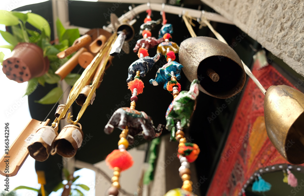 Bells, beads, paper elephants and wind chimes - symbols and signs of indian (hindu) and buddhist religions and tradition, low angle perspective. - obrazy, fototapety, plakaty 