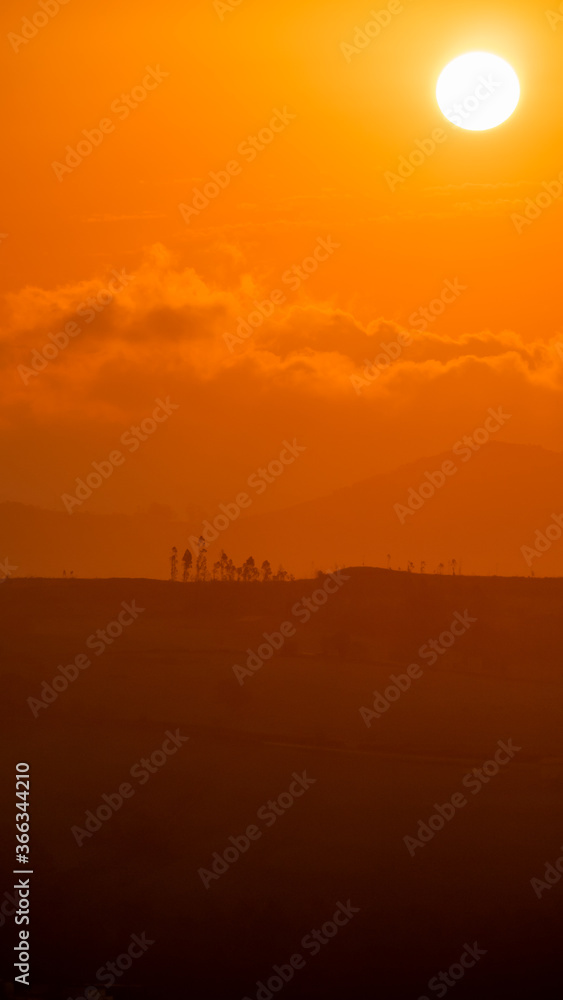 sunset between clouds and mountains in summer