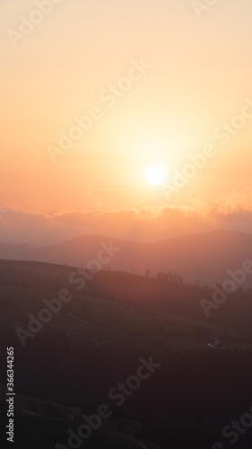 sunset between clouds and mountains in summer © infozoo