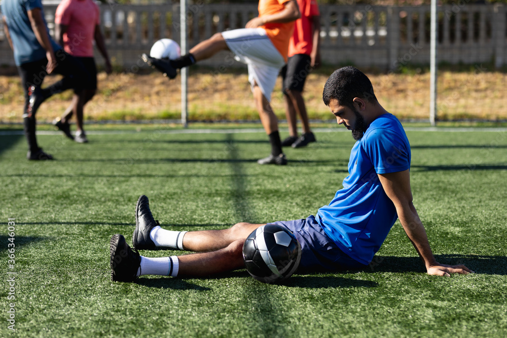 Mixed race male five a side football player training at a sports field Mixed race male five a side football player training at a sports field