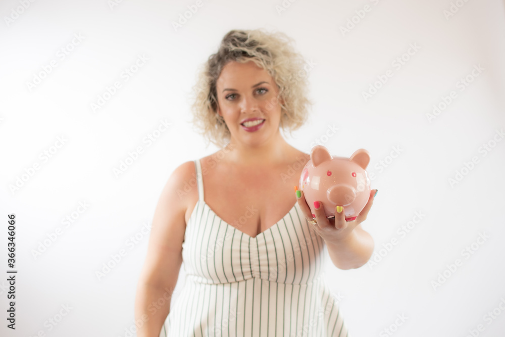 Blonde young woman with a piggy bank Blonde young woman with a piggy bank