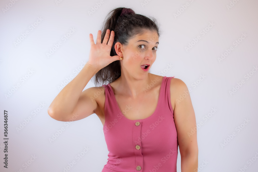 Pretty young woman with long black hair making listening gesture Pretty young woman with long black hair making listening gesture