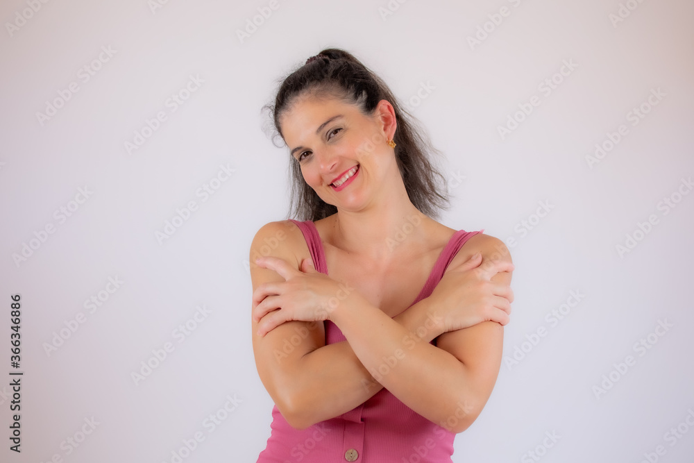 Beautiful young woman in pink shirt making a heart figure with her fingers Beautiful young woman in pink shirt making a heart figure with her fingers