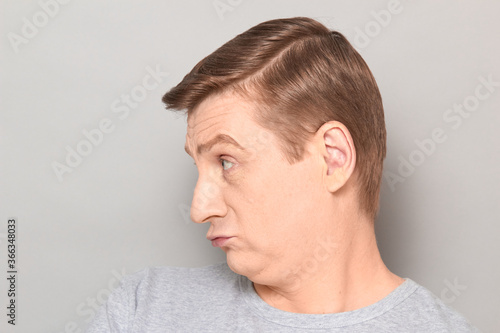 Portrait of unhappy frightened confused blond mature man