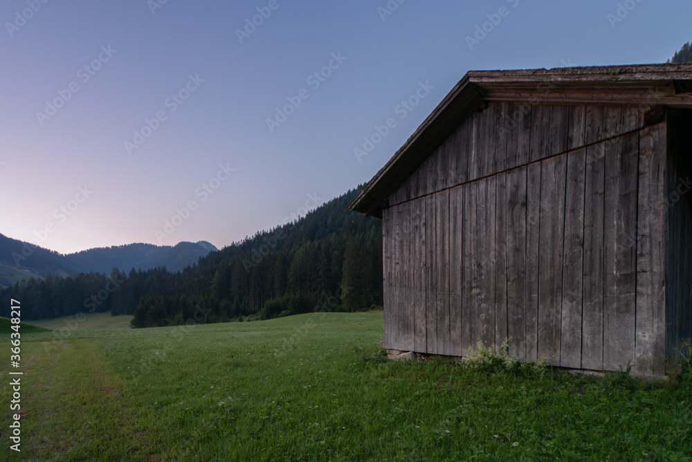 Obraz premium Wooden shed immersed in the mountain landscape