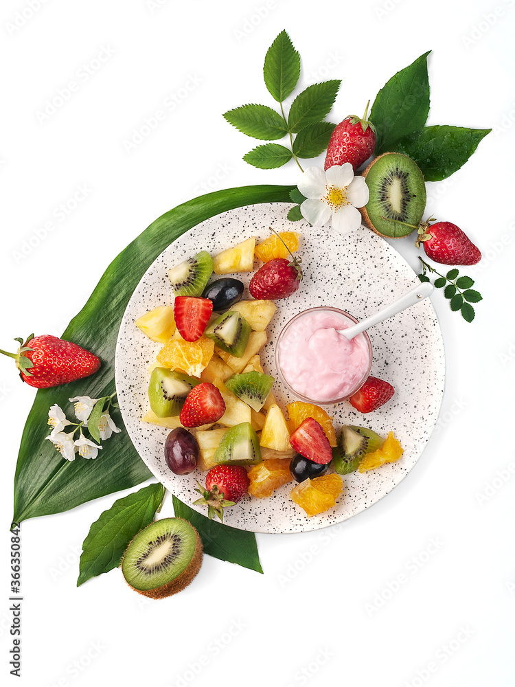 food photography of summer tropical fruit salad with yogurt sauce top view, on white background isolated with leaves and flowers close up