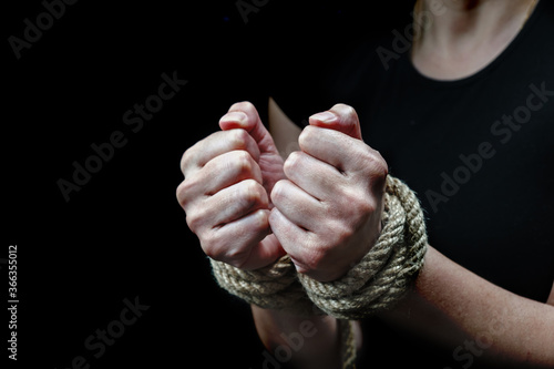 Hands of a victim woman tied up with rough rope. Stop abusing violence concept